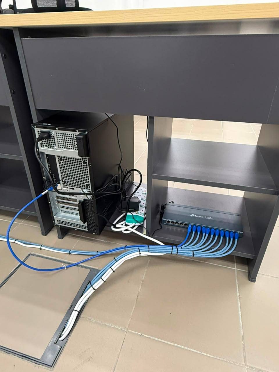 Neatly organized network cabling and switch configuration under an office workstation
