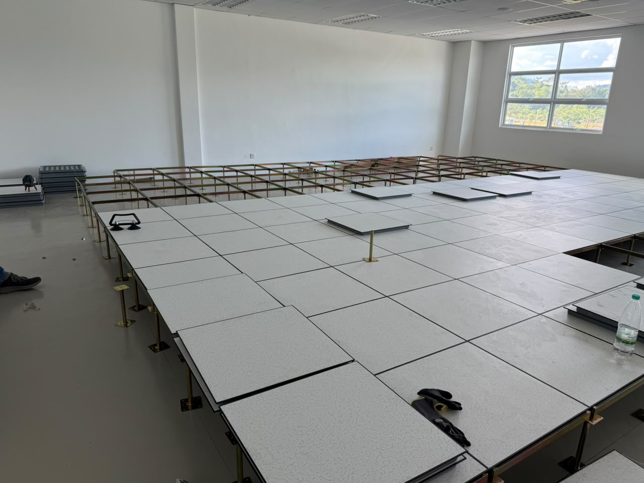 Raised access flooring panels being installed in an empty technical server room